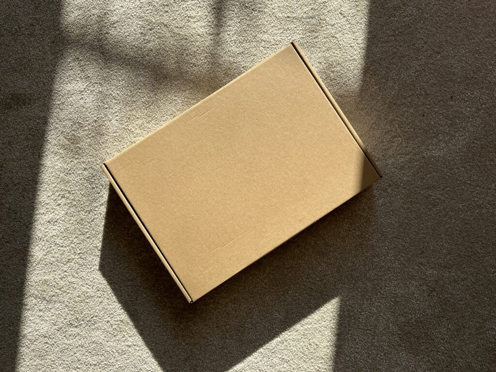 A cardboard box sits on a textured surface