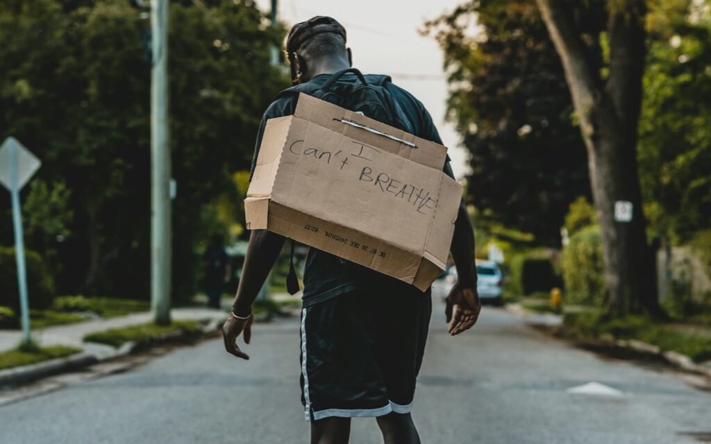Man in black jacket carrying brown cardboard box